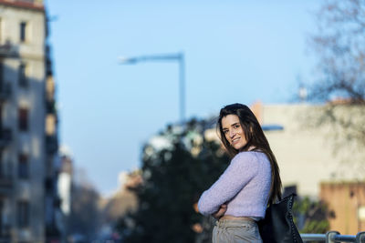 Portrait of woman standing in city