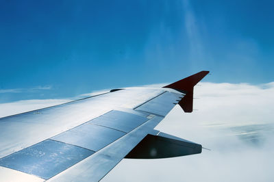 Close-up of airplane wing against sky