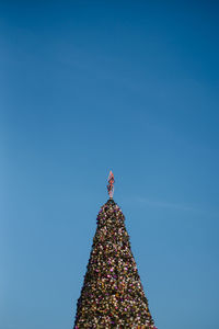 Illuminated christmas tree against blue sky