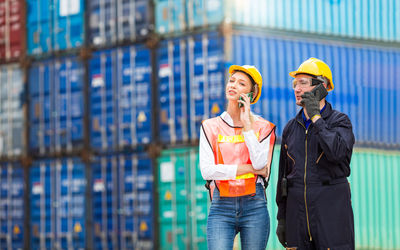 Engineers are using mobile phones in the port of loading goods.