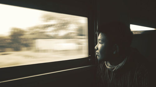 Cute boy looking towards window in train