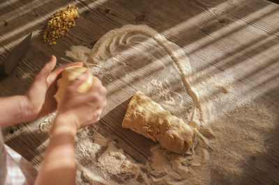 Cropped image of hand kneading dough on table