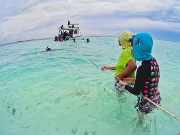 People standing on beach against sky