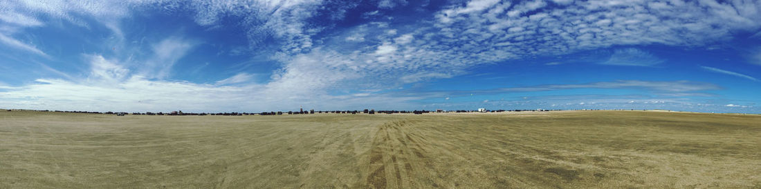 Panoramic view of agricultural field against sky