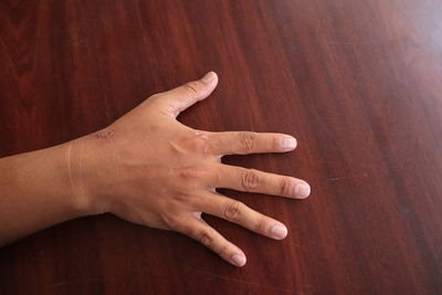 Close-up of human hand on wooden table