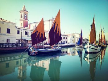 Boats in river with buildings in background