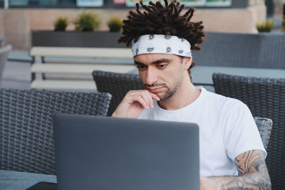 Young man using laptop while sitting at table