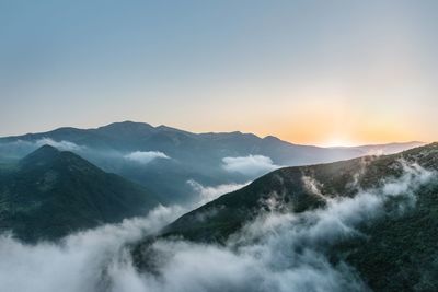 Scenic view of mountains against clear sky during sunset