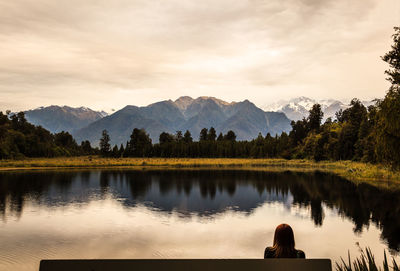 Scenic view of lake by trees against sky