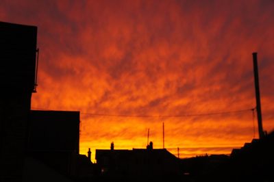 Low angle view of silhouette buildings against sky at sunset