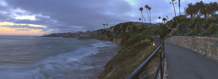 Road at heisler park by sea against sky during sunset