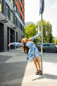 Rear view of woman with umbrella standing on street