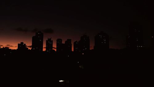 Illuminated cityscape against sky at night