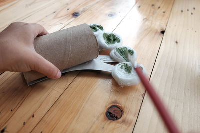 High angle view of hand holding food on wooden table