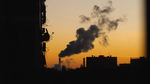 Silhouette buildings against sky during sunset