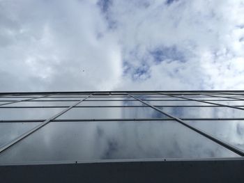 Low angle view of modern building against cloudy sky