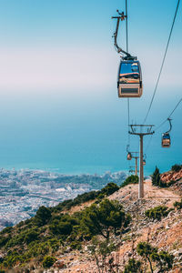 Overhead cable car over sea against sky