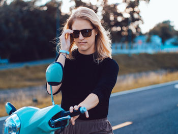 Portrait of young woman wearing sunglasses while standing outdoors