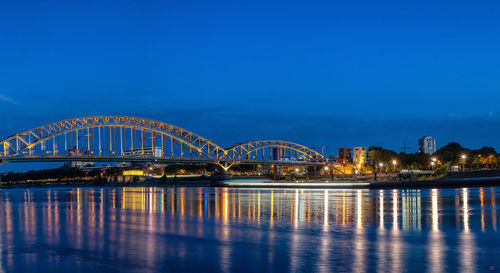 Illuminated bridge over river at night