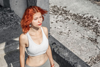 Woman in running gear, crop top and shorts, stretching her body and preparing for a run