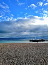 Scenic view of beach against cloudy sky