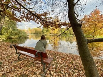 Rear view of man sitting on bench in park