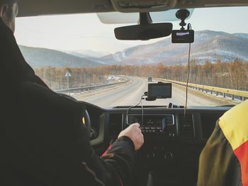 Man driving car on road against sky