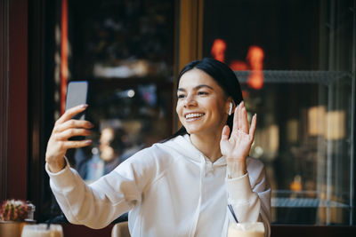 Portrait of smiling young man using mobile phone