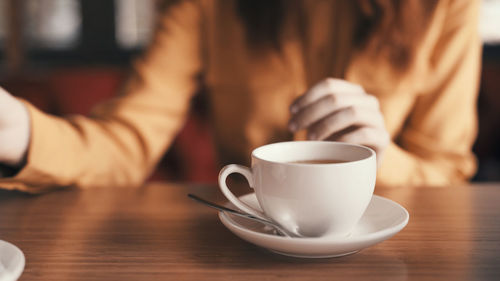 Midsection of woman using mobile phone on table