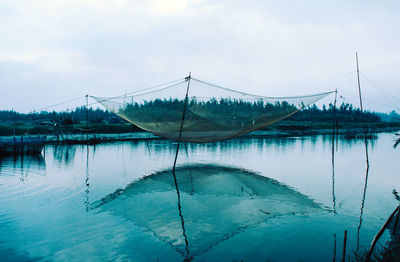 Reflection of bridge in lake against sky