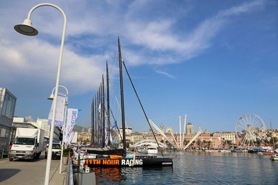 Sailboats in harbor against sky in city