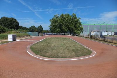 Cycle race track amidst trees against sky