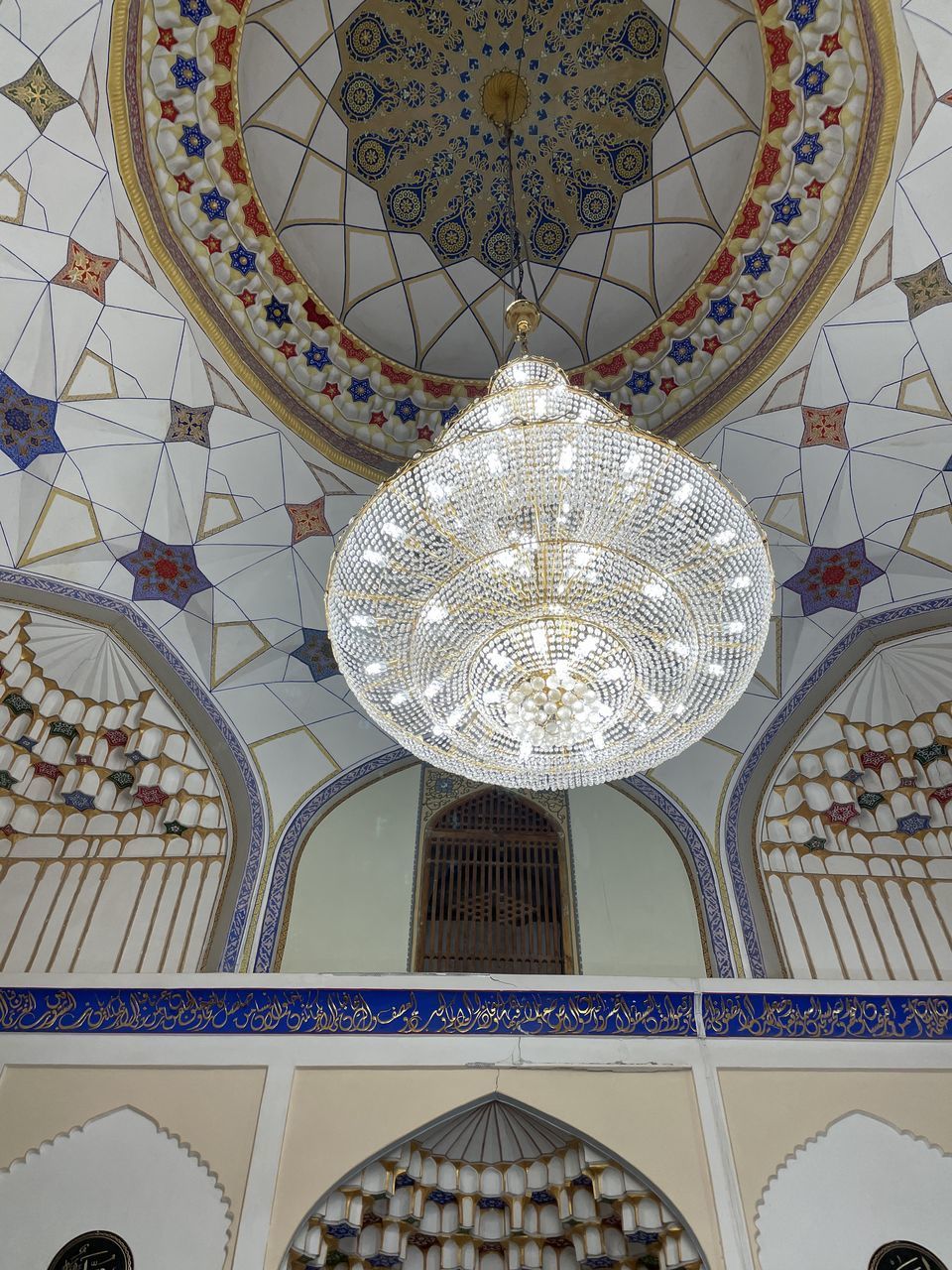 LOW ANGLE VIEW OF CHANDELIER HANGING FROM CEILING