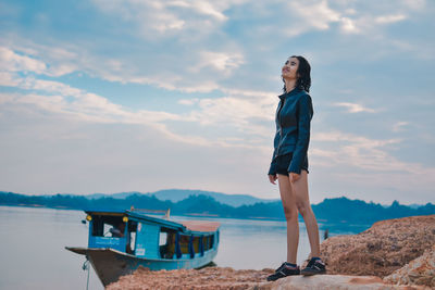 Man standing on boat in sea against sky