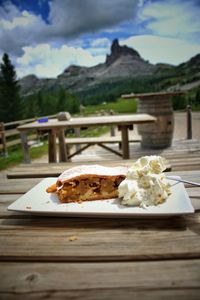 Close-up of food in plate on table against mountains