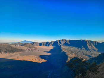 Panoramic view of desert against blue sky