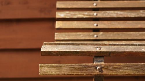 Close-up of wooden bench on sunny day