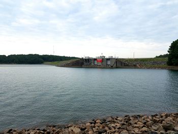 Scenic view of river against cloudy sky