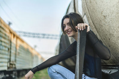 Portrait of young woman sitting at shunting yard