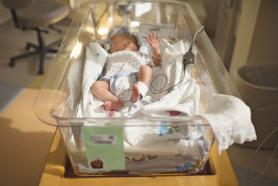 High angle view of newborn baby boy sleeping in crib at hospital