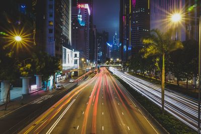 High angle view of light trails on road amidst buildings at night