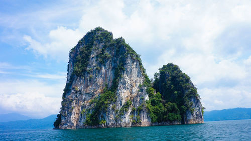 Scenic view of rock formation in sea against sky