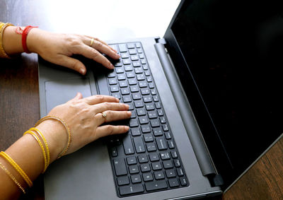 Cropped hands using laptop