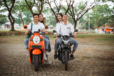Side view of man riding motor scooter on road
