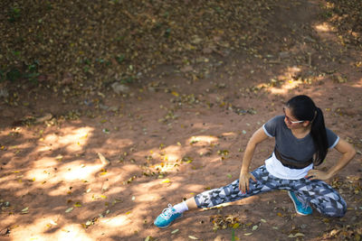 High angle view of young woman sitting on land