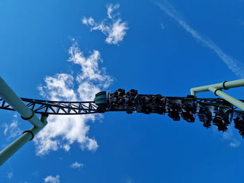 Low angle view of electricity pylon against blue sky