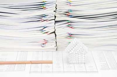 Close-up of model house and pencil on financial documents