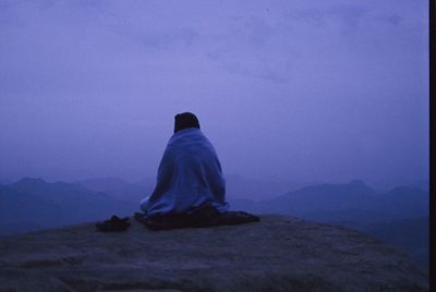 Rear view of man on mountain against sky