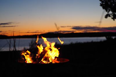 Close-up of bonfire against sky at sunset