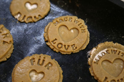 Close-up of raw cookies with text on baking sheet